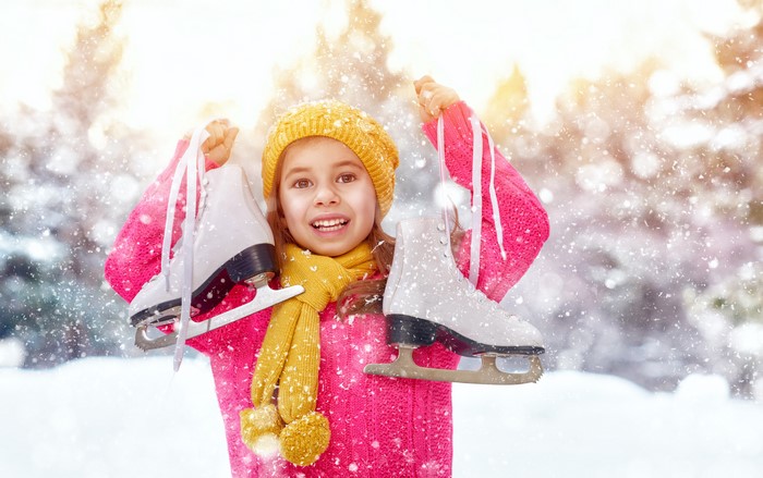 Girl in Winter Hat Holding Ice Skates