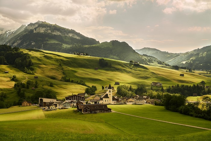 Village in the Swiss Alps with rolling green hills