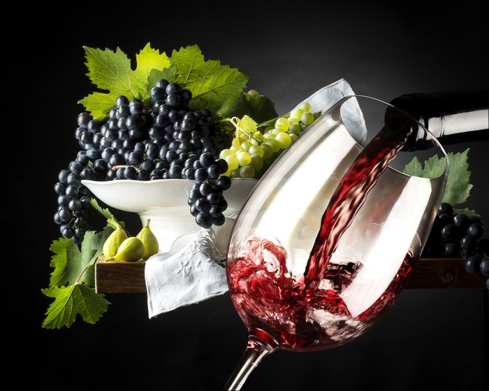 Red Wine Pouring into Glass with Grapes and Figs