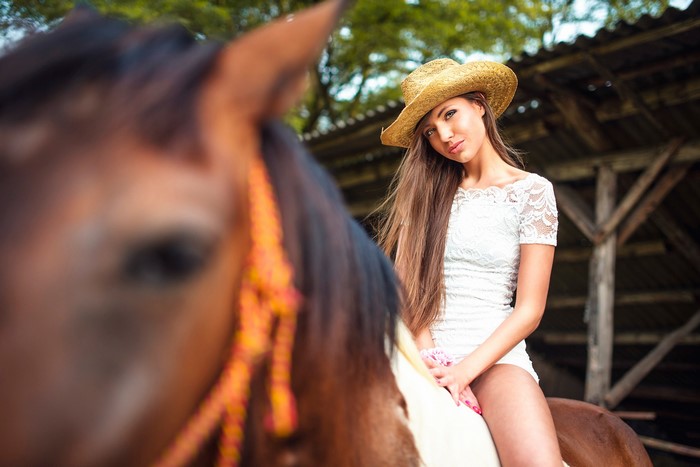 Woman in cowboy hat riding a horse