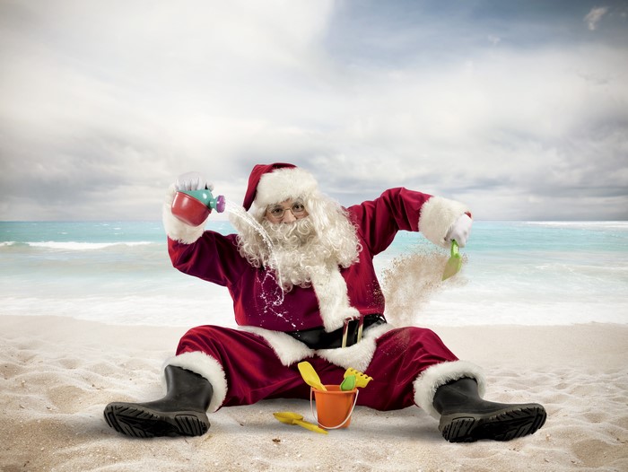 Santa Claus playing on a beach with toys