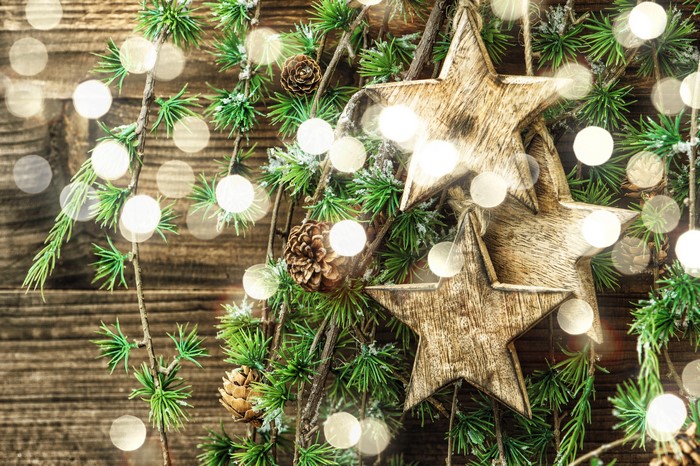 Christmas tree branches with wooden stars and fairy lights