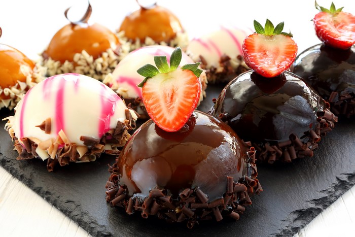 Assortment of small cakes with strawberries and chocolate