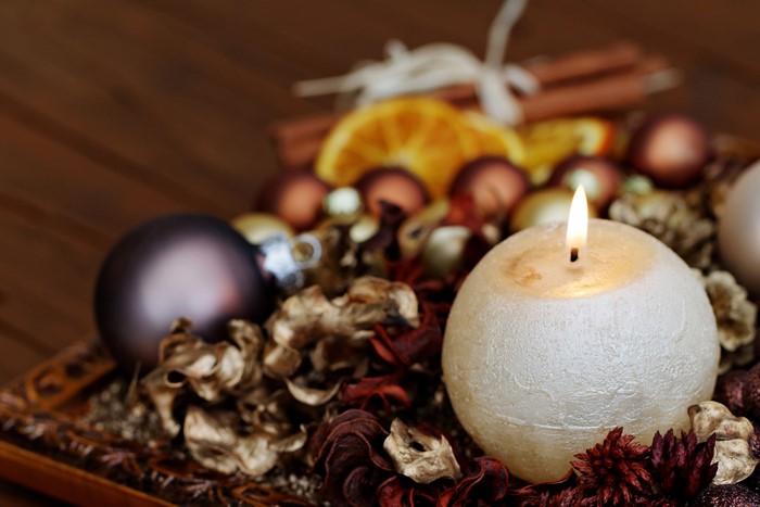 Christmas candle with ornaments and dried fruit