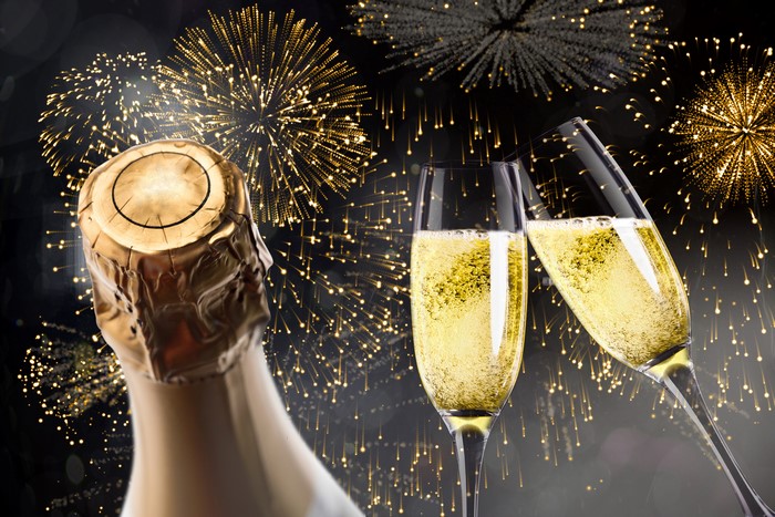 Champagne bottle and glasses with fireworks