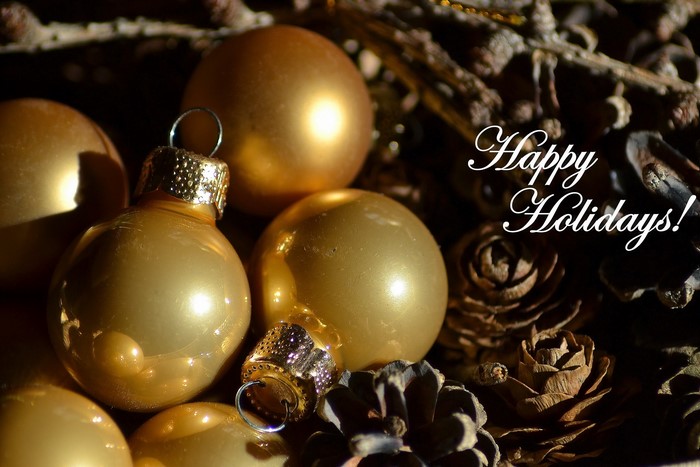 Golden Christmas Ornaments and Pine Cones with Happy Holidays Text