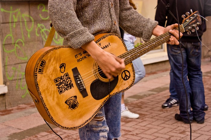 Person playing guitar with stickers