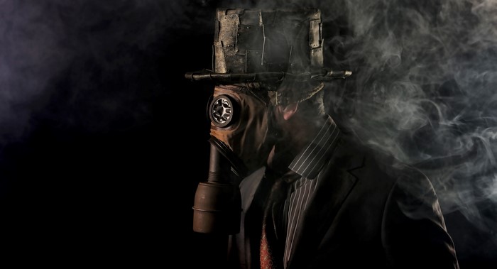 Man in gas mask and hat with smoke