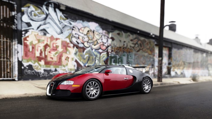 Bugatti Veyron parked in front of graffiti wall