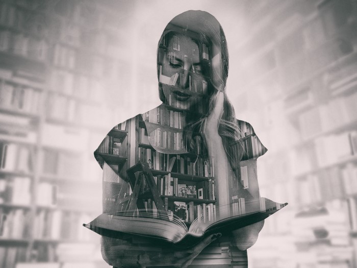 Double exposure of woman reading in library