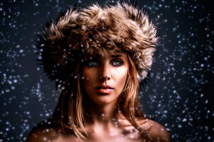 Woman in fur hat with snow falling