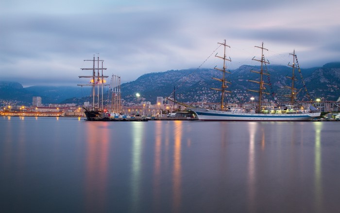 Tall ships docked in Toulon harbor at dusk