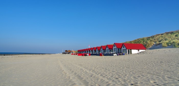 Beach houses with red roofs on a sandy beach