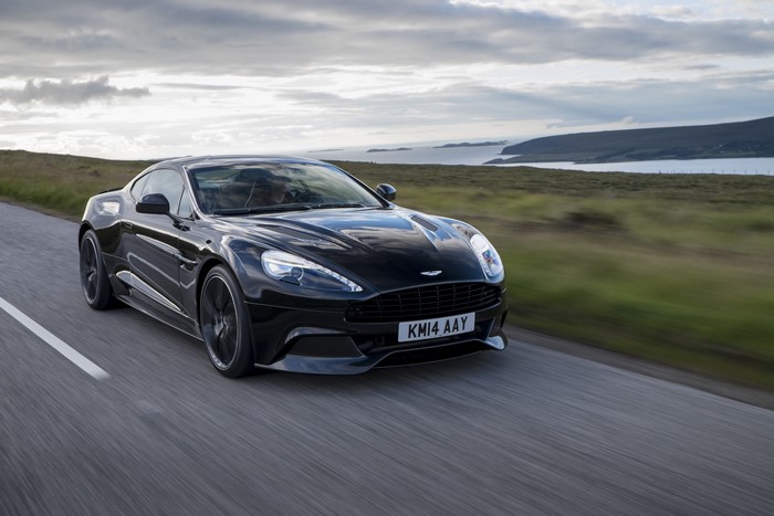 Black Aston Martin Vanquish driving on a road
