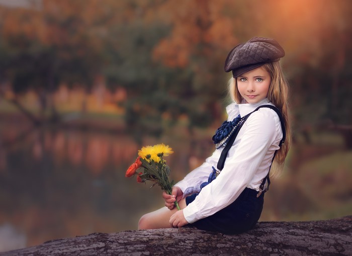 Little girl sitting with flowers