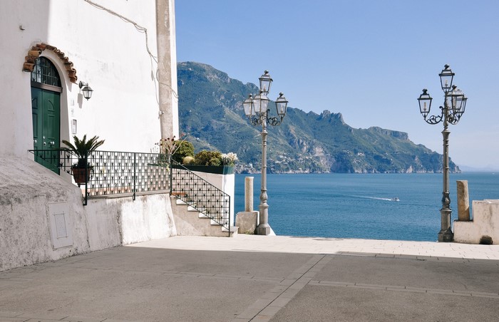 White building with green door overlooking the sea and mountains