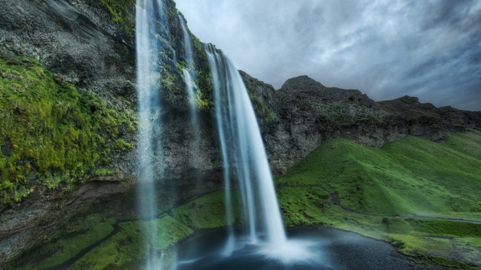 Seljalandsfoss waterfall in Iceland under a cloudy sky