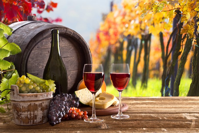 Wine, Grapes, Barrel, Cheese, and Stemware in a Vineyard