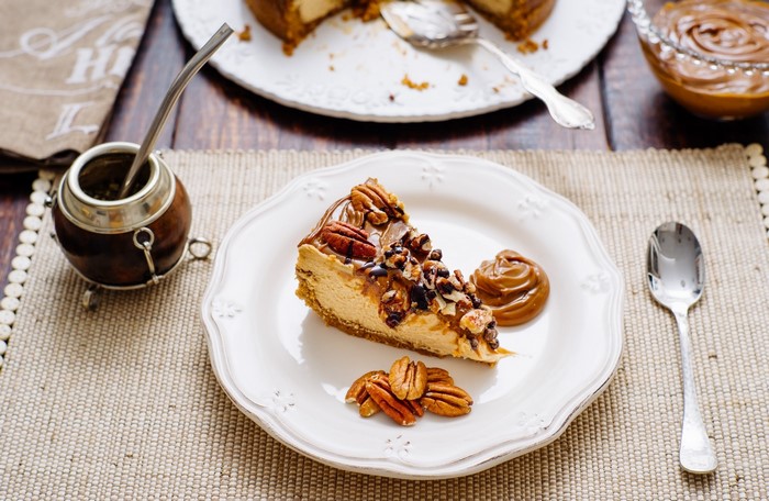 Slice of caramel pecan cheesecake with mate tea