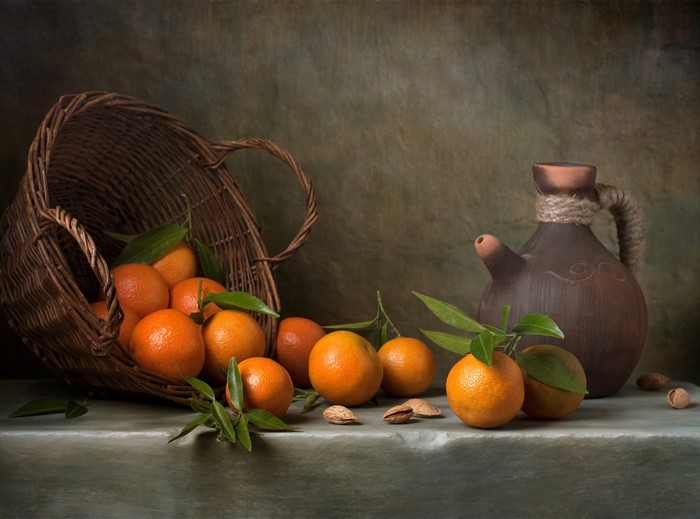 Still life with tangerines in a wicker basket and a jug