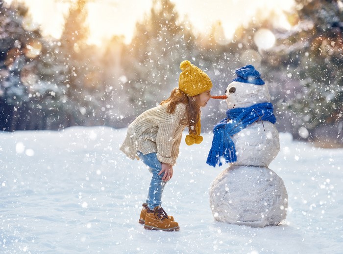 Girl and Snowman in Winter Snowfall