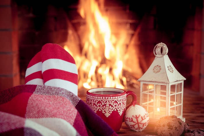 Cozy Christmas scene with feet by the fireplace