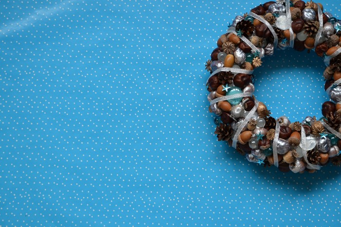 Christmas wreath with natural elements on blue polka dot background