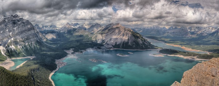 Turquoise lake surrounded by mountains under cloudy sky