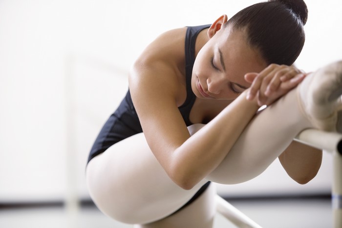 Ballet dancer stretching at barre