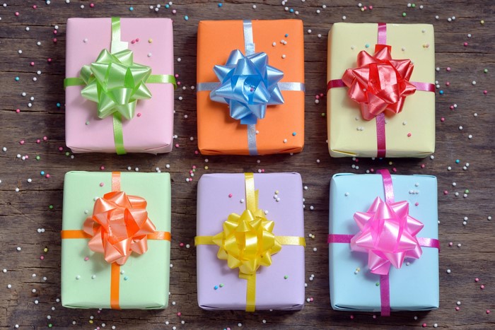 Six colorful gift boxes with bows on wooden background