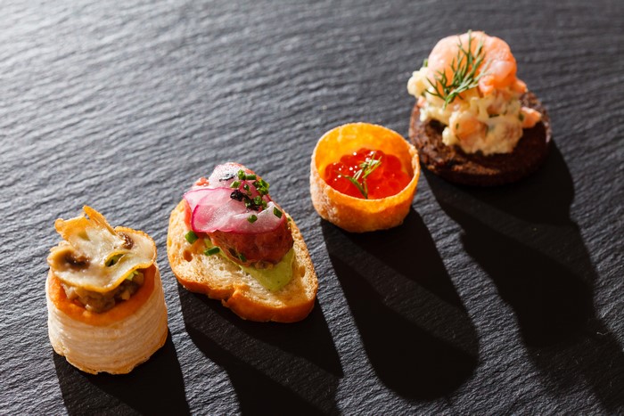 Assortment of gourmet appetizers on a dark slate surface