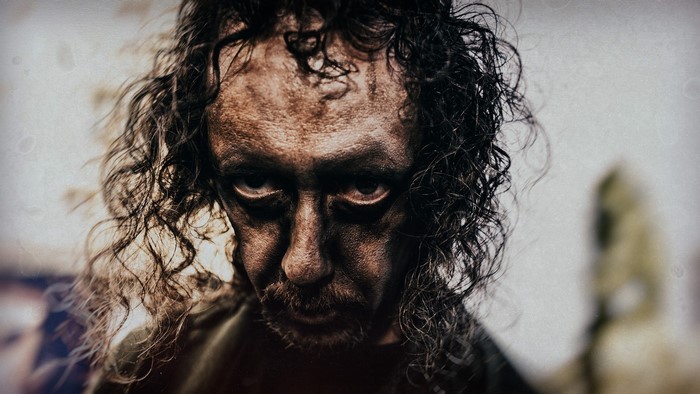 Man with messy hair and dark makeup