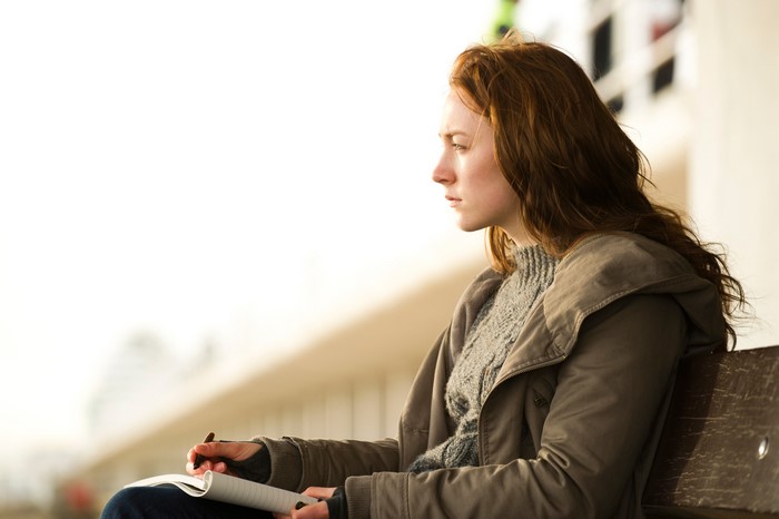 Saoirse Ronan writing in a notebook