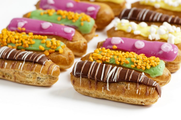 Assortment of colorful eclairs with various toppings