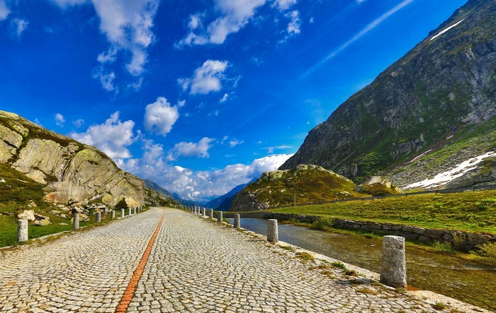 Cobblestone Road Through Mountains with River
