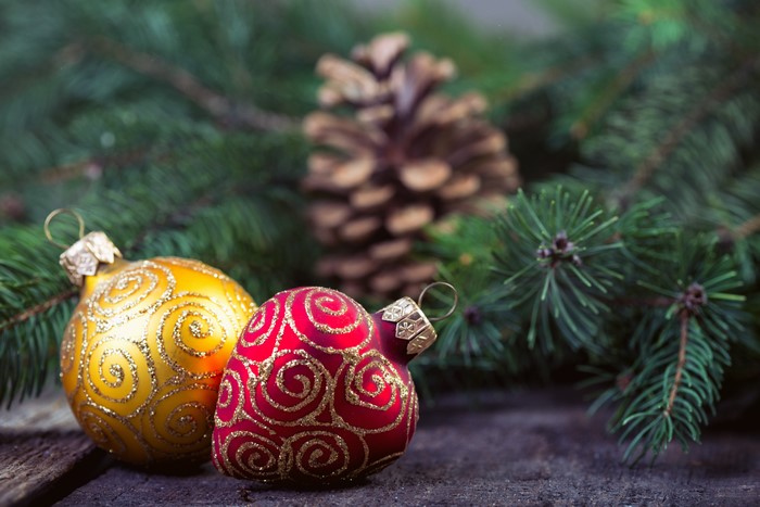 Christmas ornaments and pine cone on branches