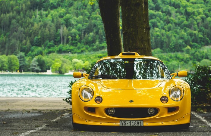 Yellow Lotus Exige S1 sports car parked by a lake