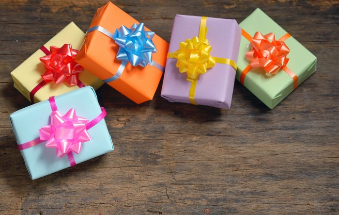Colorful gift boxes with bows on wooden background