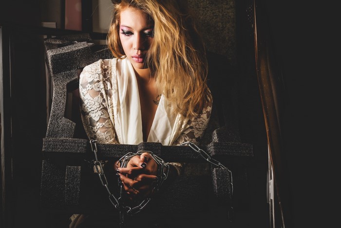 Woman chained in a dark room