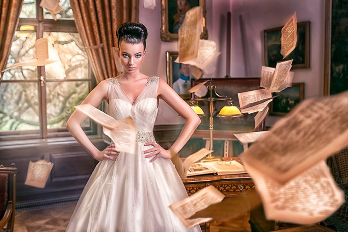 Woman in wedding dress with flying papers