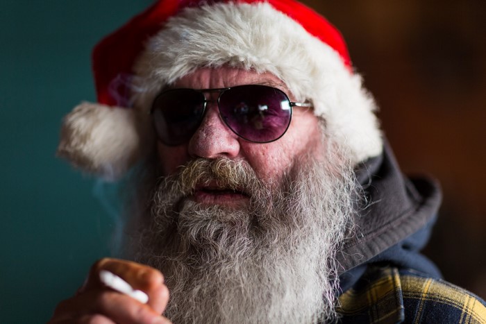 Man in Santa hat and sunglasses smoking