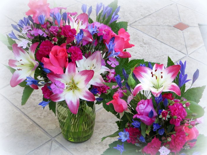Pink and white lilies, roses, and bluebells in bouquets