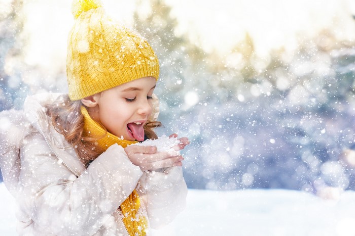 Girl in Winter Hat Eating Snow