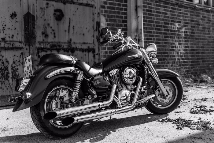Black motorcycle parked near brick wall