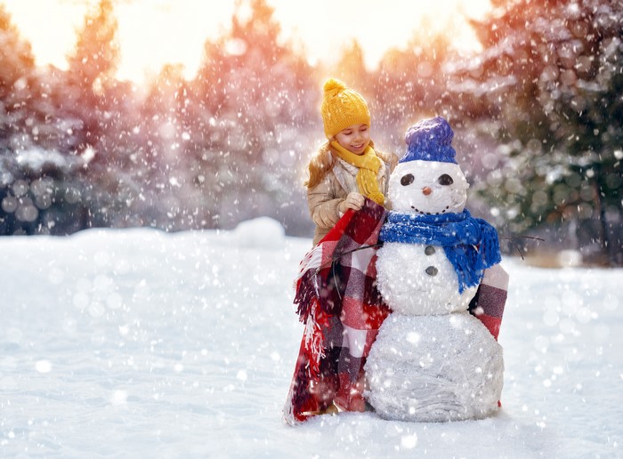 Girl with Snowman in Winter Forest