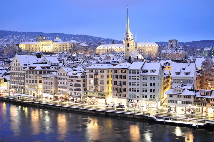 Zurich cityscape with river and snow-covered buildings in winter
