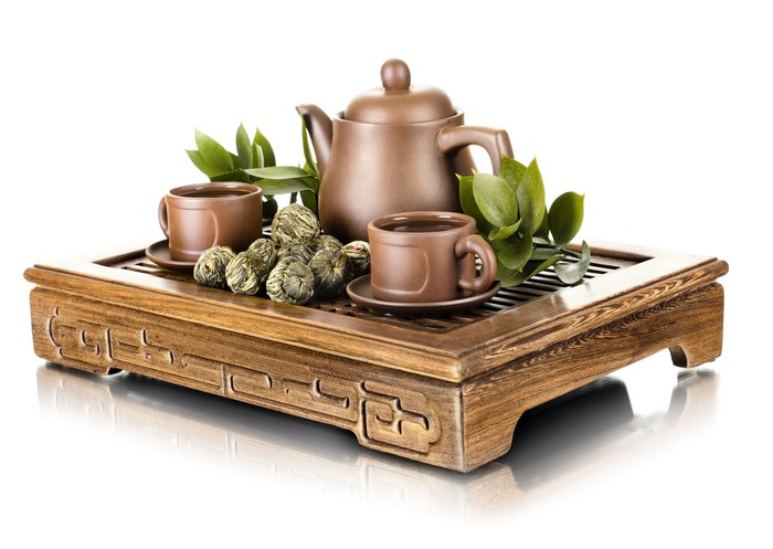 Tea set with cups, teapot, and tea balls on a wooden tray
