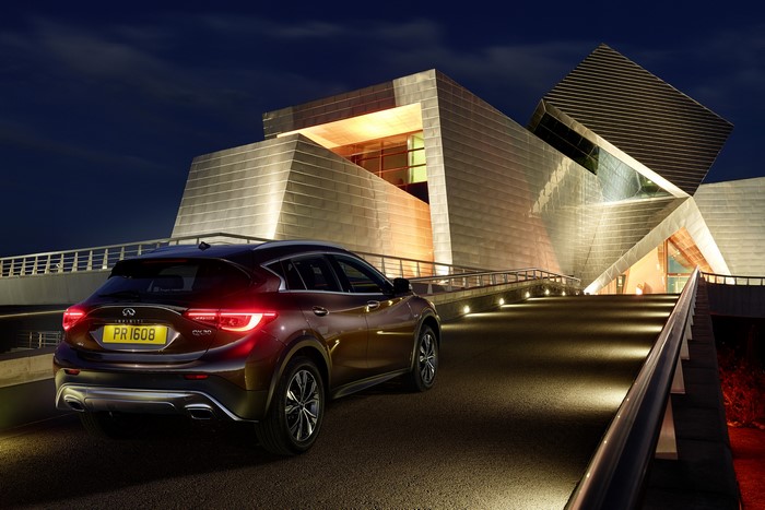 2015 Infiniti QX30 parked at modern building at night