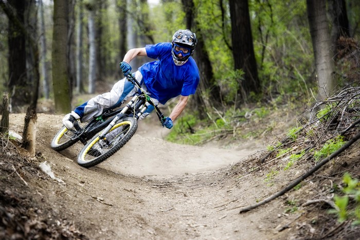 Man riding a downhill mountain bike on a dirt trail