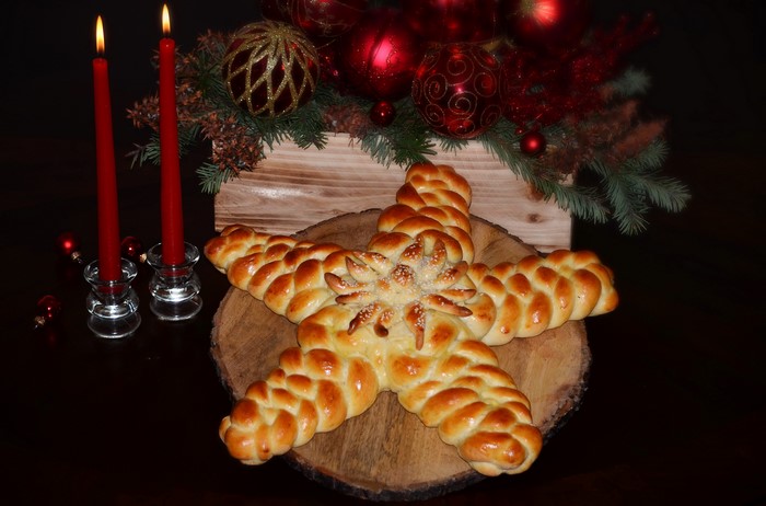 Star-shaped pastry with Christmas decorations and candles